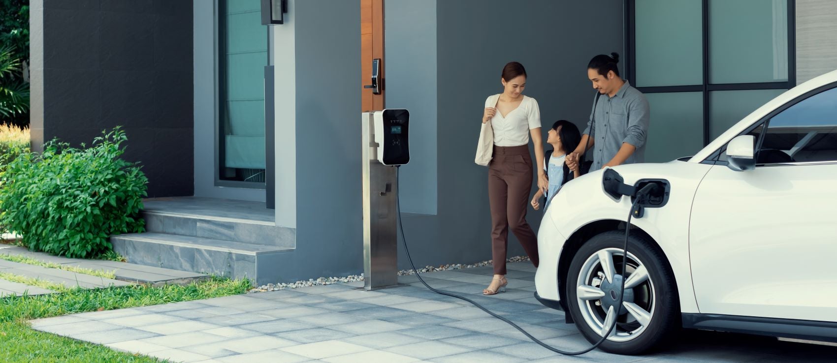 Family Standing Next to Their EV